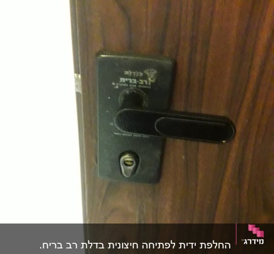 מנעול דלת עם ידית שחורה על דלת עץ